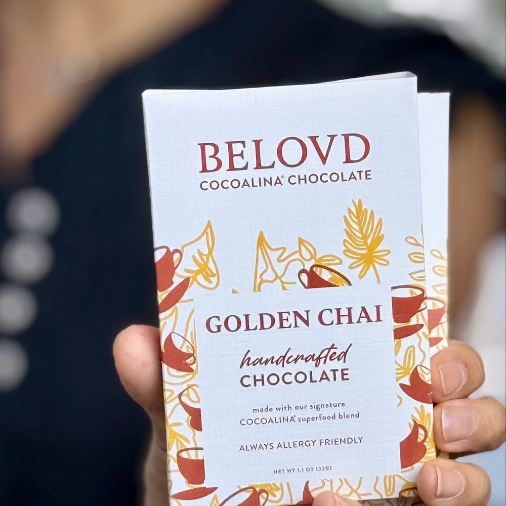 Hand holding Belovd Golden Chai Chocolate Bar in packaging
