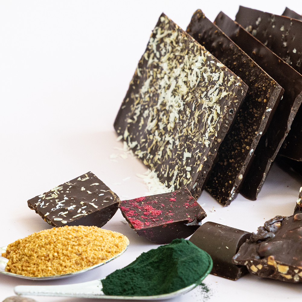 Belovd Chocolate bars and ingredients on spoons in the foreground