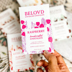 Hand holding Belovd Raspberry Chocolate Bar in Packaging
