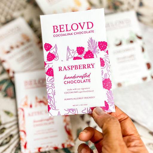 Hand holding Belovd Raspberry Chocolate Bar in Packaging