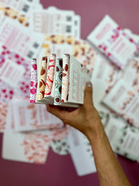 Hand holding several Belovd chocolates in packaging